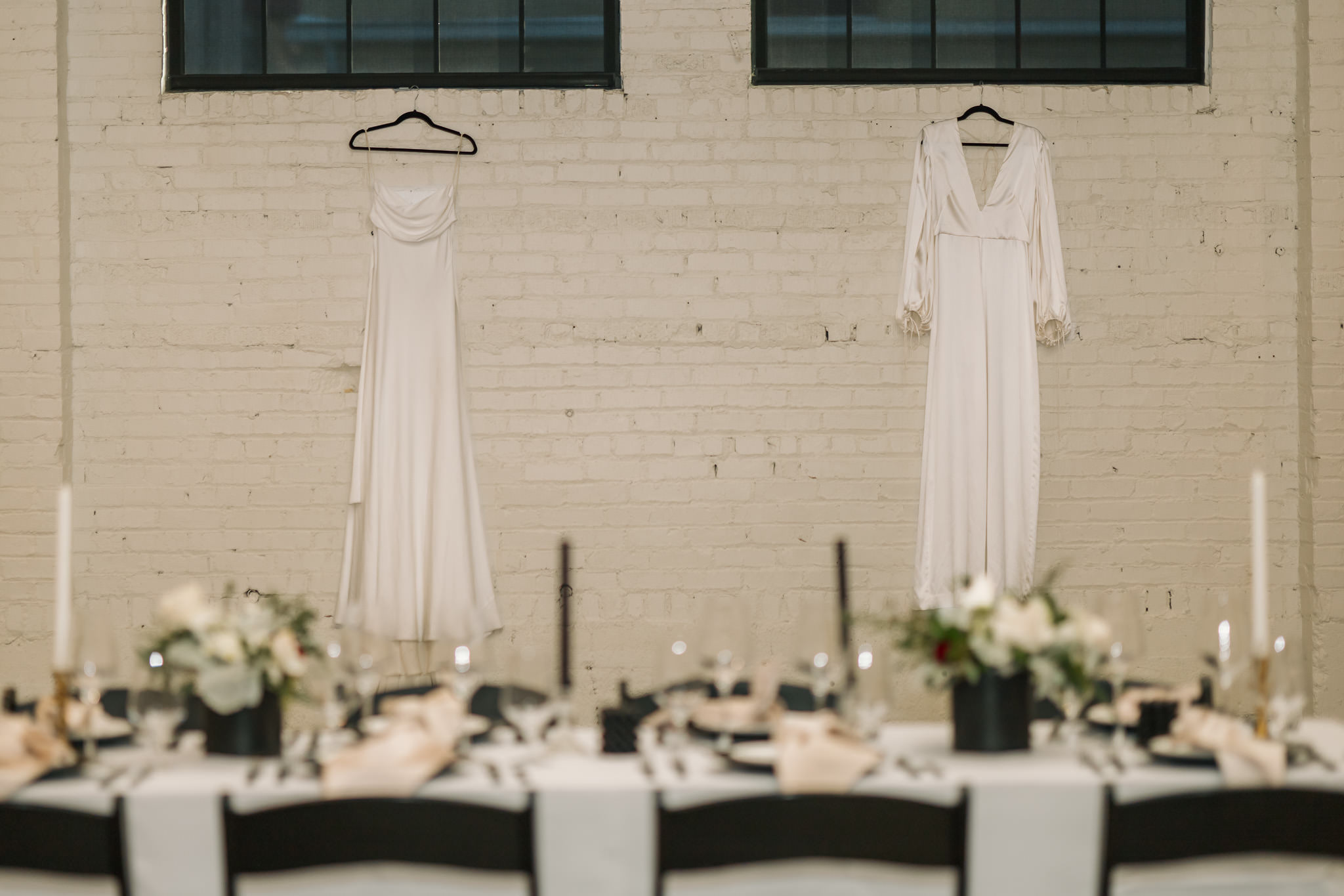 planning - two brides dresses hanging on the wall